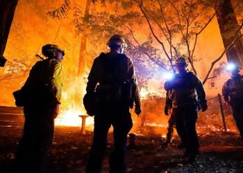 Firefighters make a stand in the backyard of a home in front of the advancing CZU August Lightning Complex Fire Friday, Aug. 21, 2020