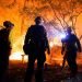 Firefighters make a stand in the backyard of a home in front of the advancing CZU August Lightning Complex Fire Friday, Aug. 21, 2020