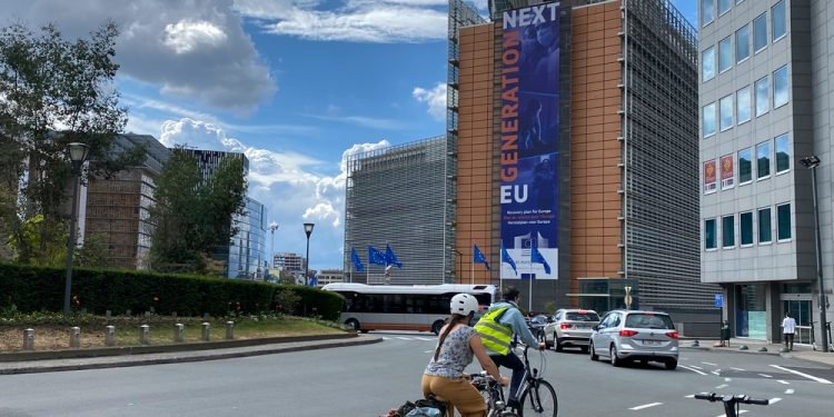 A rider passes with her bike in front of EU Headquarters in Brussels, Belgium