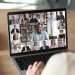 Back view of female employee speak talk on video call with diverse multiracial colleagues on online briefing, woman worker have Webcam group conference with coworkers on modern laptop at home