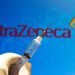 In this photo illustration the medical syringe (coronavirus vaccine) is seen with AstraZeneca PLC company logo displayed on a screen in the background