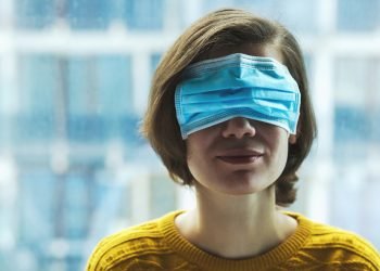 Woman in medical mask on eyes. Panic, fear, lying or disinformation during coronavirus pandemic concept.