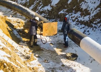 The workers engaged in the construction of the pipeline. Welders build the pipeline. Installation work in the construction and installation of the pipeline.