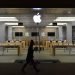A silhouetted passerby walking a dog passes the exterior of an Apple store as the US technology giant launches new products in Europe and America.