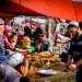 KASHGAR, CHINA - Oct 2011: A Uyghur man serves food to a group of people at the Yopurga weekly market near Kashgar in the Xinjiang Uygur Autonomous Region in western China