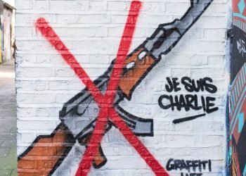 Graffiti representing an AK47 rifle with a red cross on it to show solidarity against terrorism after Paris Charlie Hebdo attack on the 7th January 2015