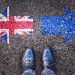 Brexit, flags of the United Kingdom and the European Union on asphalt road with legs