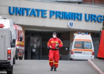 Bucharest, Romania - April 1, 2020: Romanian medical personnel wearing protective suits in the yard of a hospital closed for Covid-19 infection.