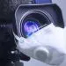 Berlin, Germany 03/12/2020 - Media virus Covid-19 background. Broadcast camera with pandemic 2019-nCoV protection mask on lens. Media broadcast and financial journalism due to cancellations concept