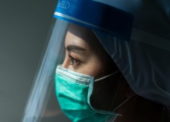 Closeup Asian female Doctor wearing face shield and PPE suit for Coronavirus outbreak or Covid-19