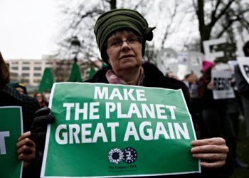 People hold placards and shout slogans during a protest against Trump's environmental policy at conference attended by Trump climate advisor Myron Ebell in Brussels, Belgium on Feb. 2017