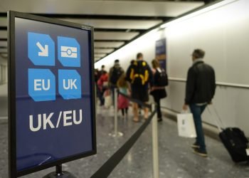 London, UK - April 15, 2018: Air travelers proceed along the UK/EU arrivals lane to passport control at Heathrow airport.