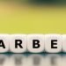 Hand turns a dice and changes the German word "Zeitarbeit" ("time-work" in English) to "Leiharbeit" ("temporary work" in English).