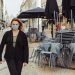 Millennial woman wearing a safety mask standing in the street near a closed restaurant during Covid-19 pandemic in Lisbon, Portugal. Safety or protection concept