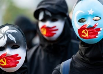 HONG KONG - DECEMBER 22 2019: A group of protestors wear masks symbolizing the Communist Party of China's silencing of Uyghur Muslims and the Hong Kong pro-democracy movement at a rally in Hong Kong.