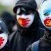 HONG KONG - DECEMBER 22 2019: A group of protestors wear masks symbolizing the Communist Party of China's silencing of Uyghur Muslims and the Hong Kong pro-democracy movement at a rally in Hong Kong.