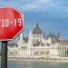 Covid-19 sign with parliament building in Budapest, Hungary. Coronavirus pandemic outbreak concept.