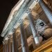 Night view of the main facade of the Palacio de la Cortes, palace of courts, seat of the Congress of Deputies in Madrid, Spain, with one of its iconic bronze lions in the foreground