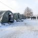 Bihac, BiH 15 Jan 2021: Tents in migrant camp "Lipa" in Bihac, Bosnia and Herzegovina. Group of refugees in snow during cold winter day. Balkan route.