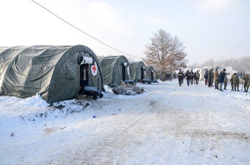 Bihac, BiH 15 Jan 2021: Tents in migrant camp "Lipa" in Bihac, Bosnia and Herzegovina. Group of refugees in snow during cold winter day. Balkan route.