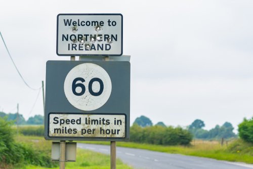 Editorial use only; a signpost and speed limit sign, the sign has the text ' Welcome to Northern Ireland ', taken outside Ballyconnell, Co. Cavan, Ireland, in July 2017.