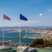 Gibraltar, United Kingdom, 1st October 2018:- View from the top of the Rock into Spain, with the flags of Gibraltar, UK and EU flying. Gibraltar is a British Overseas Territory.