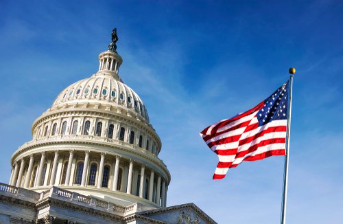 American flag waving with the Capitol Hill in the background