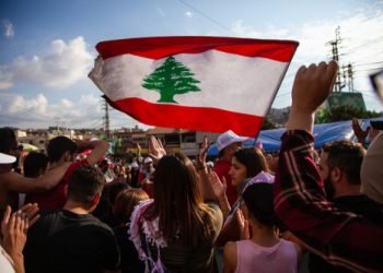 Nabatieh, South Government / Lebanon - 10 20 2019: Lebanese Protesters rising Lebanon Flag in the Sky at the Revolution against the Government