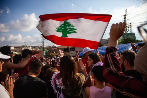 Nabatieh, South Government / Lebanon - 10 20 2019: Lebanese Protesters rising Lebanon Flag in the Sky at the Revolution against the Government