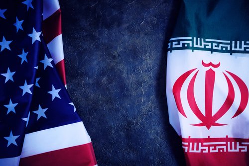 Flags of Iran and United States of America are opposite each other dark background