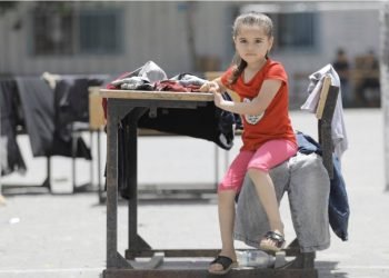 Displaced by airstrikes, a Palestine refugee child sits in the school yard of the UNRWA Salah Eddin School, one of 58 shelters of its kind in Gaza. These UNRWA schools have been designated as shelters for Palestine refugees during times of conflict. 17 May 2021 © 2021 UNRWA Photo By Mohamed Hinnawi