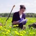 Scientist ecologist on the meadow writing something on the envelope.