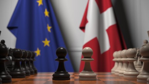 Flags of the EU and Switzerland behind chess board. The first pawn moves in the beginning of the game. Political rivalry conceptual 3D rendering