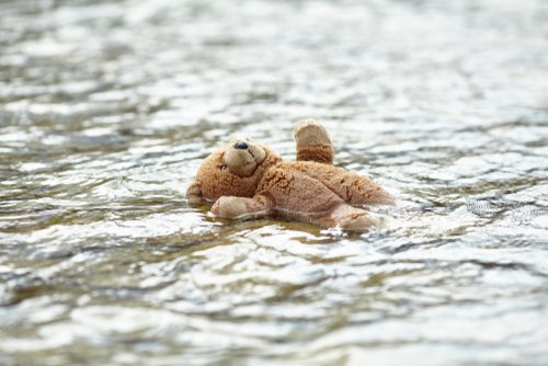 Children's toy by the sea. Homeless child. Refugee problem. Concept of finding a better life.