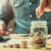 businessman holding coins putting in glass. concept saving money for finance accounting