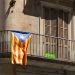 View of the historic building in Barcelona center with blue Estelada flag on the balconies. The Estelada is an unofficial flag typically flown by Catalan independence supporters. Spain.