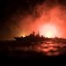 War concept. Night battle scene at sea. Dramatic toned clouds effect. Silhouette of the battle ship in night. Miniature creative table decoration. Selective focus