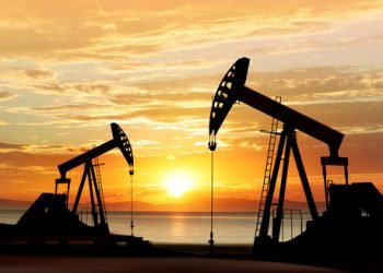 silhouette of working oil pumps on sunset background