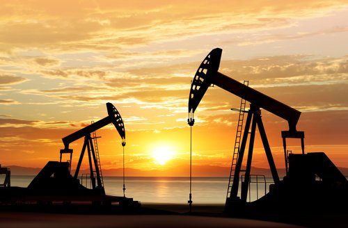 silhouette of working oil pumps on sunset background