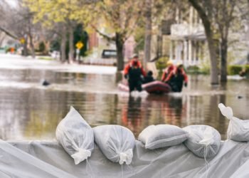 Flood Protection Sandbags with flooded homes in the background (Montage)