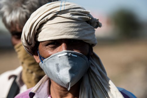 MUMBAI/INDIA - MAY 11, 2020: Migrant workers wearing mask on their journey back home during a nationwide lockdown to fight the spread of the COVID-19 coronavirus.