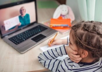 Pretty stylish schoolgirl studying homework math during her online lesson at home, social distance during quarantine, self-isolation, online education concept, home schooler