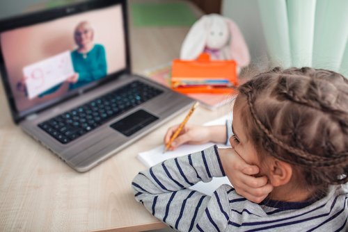 Pretty stylish schoolgirl studying homework math during her online lesson at home, social distance during quarantine, self-isolation, online education concept, home schooler