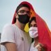 Warsaw, Poland, June 2020: LGBT supporters wearing face masks protesting on the street with rainbow flags. Concept of gay couples rights