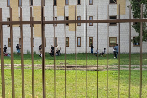 Pabrade Lithuania - July 17 2021: Group of migrants in Pabrade Detention Centre. Buildings to accommodate immigrants coming over Belarussian Lithuanian border. Tiny rural town.