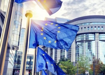 EU flags waving in front of European Parliament building. Brussels, Belgium