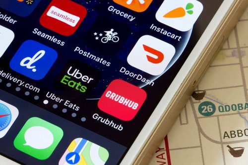 Portland, OR, USA - Apr 30, 2020: Mobile app icons of assorted food delivery services are seen on a smartphone, including DoorDash, Grubhub, Uber Eats, delivery.com, Seamless, Postmates and Instacart.