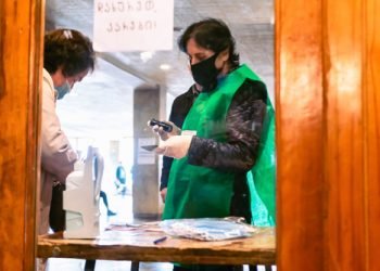 Tbilisi, Republic of Georgia- 31 October,2020.Georgian parliament elections. Woman at security checks female citizen ID and holds stamp before letting to ente to vote.