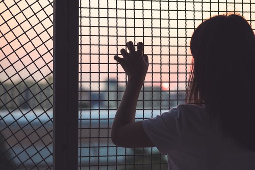 Woman's-hand-grabs-the-fence-Greece