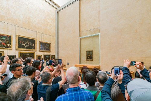 Tourist,Photographing,The,Famous,Mona,Lisa,Painting,In,The,Louvre